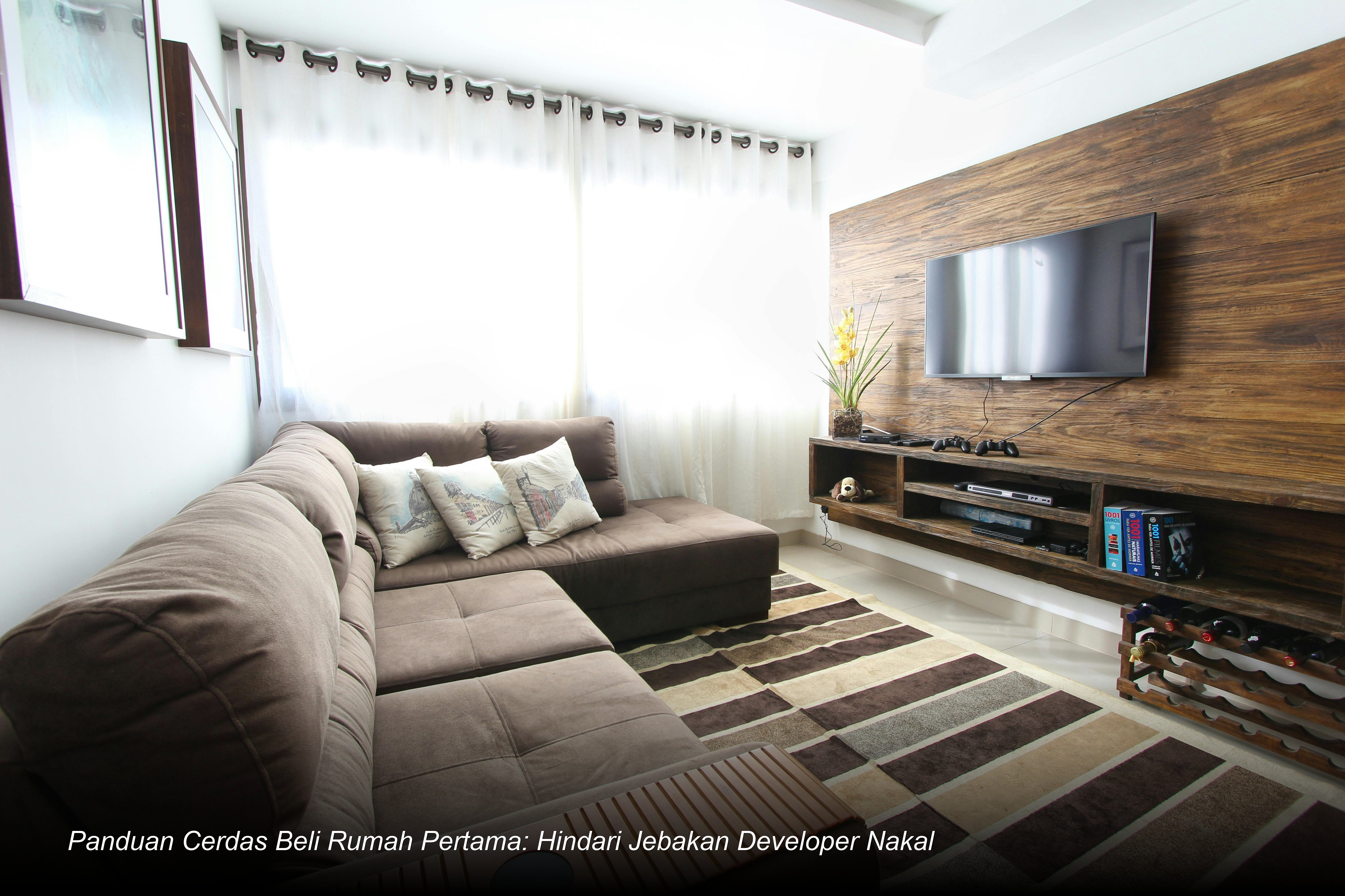 Seorang pasangan muda sedang menandatangani dokumen perjanjian kredit di meja Notaris dengan didampingi analis bank.