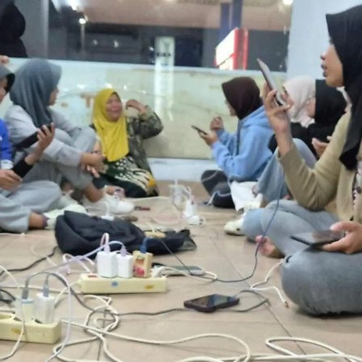 Sejumlah warga mengisi daya gawai di lokasi yang tidak terdampak pemadaman listrik di Kota Padang Jumat (22/5/2026) malam. (ANTARA/Dokumentasi Pribadi)