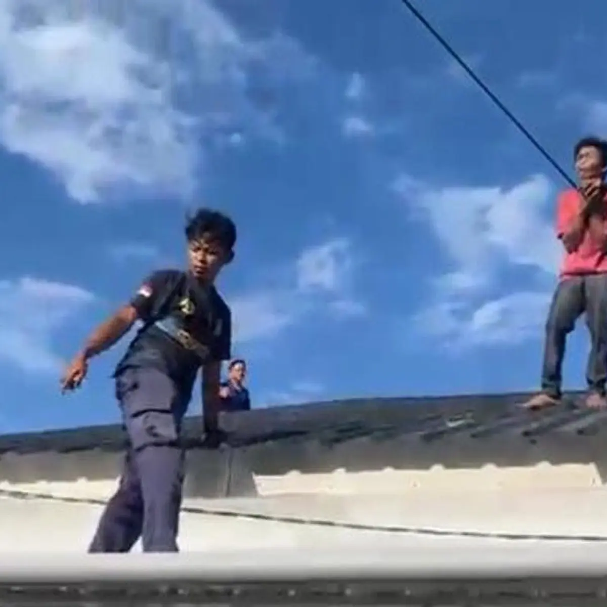 Foto: Petugas Damkar Parepare mengevakuasi pemuda yang terjebak di atap rumah. (dok. Istimewa)