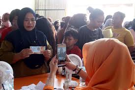 Warga mengantri mengambil Bantuan Sosial dari pemerintah dikantor PT Pos di Makassar, Sulawesi Selatan, Jumat (25/11). Bisnis/Paulus Tandi Bone