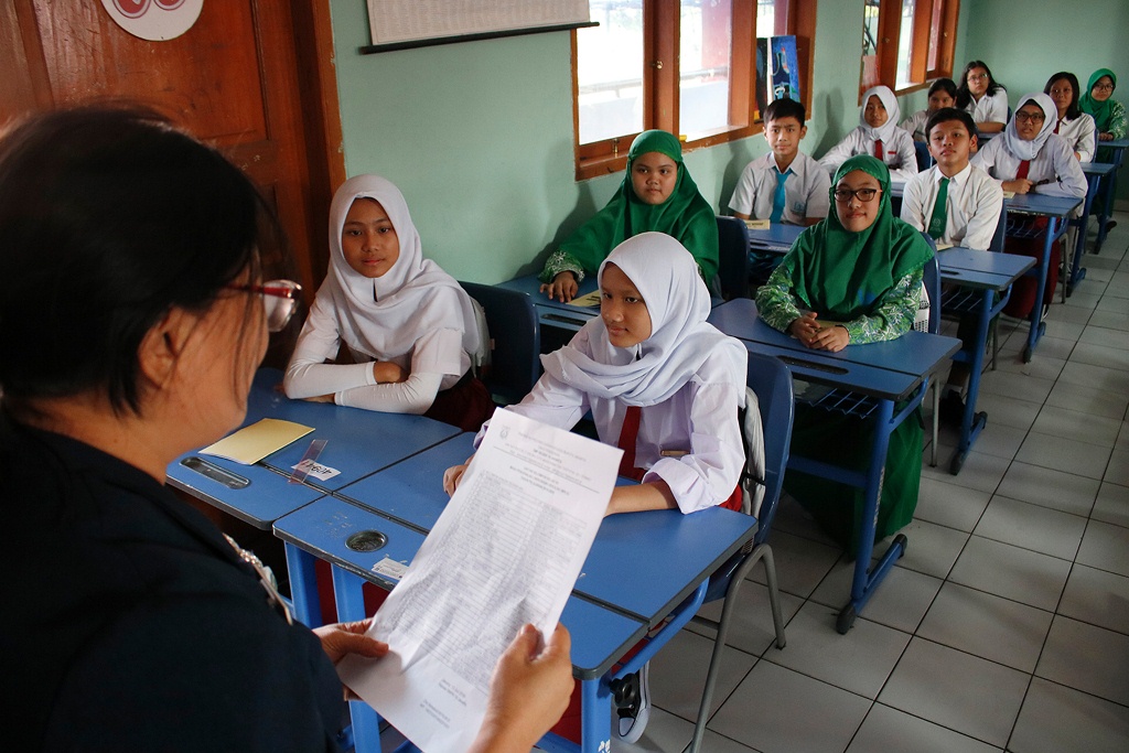 Guru mengajar di kelas. Foto: MI/Barry Fatahillah