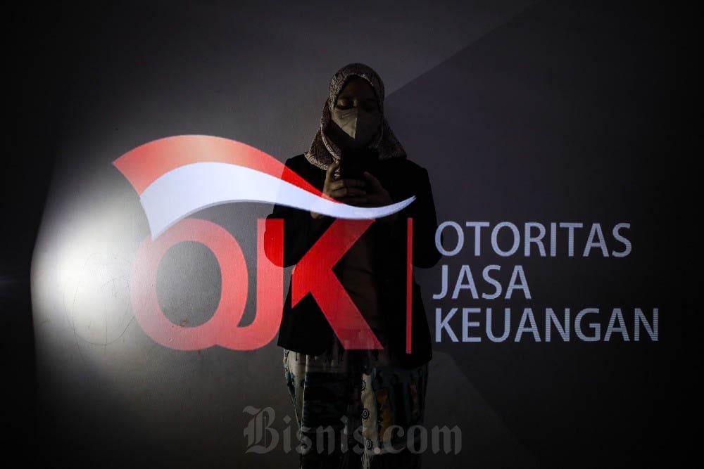 Foto multiple exposure warga beraktivitas di dekat logo Otoritas Jasa Keuangan (OJK) di Jakarta, Minggu (31/12/2023). Arief Hermawan P