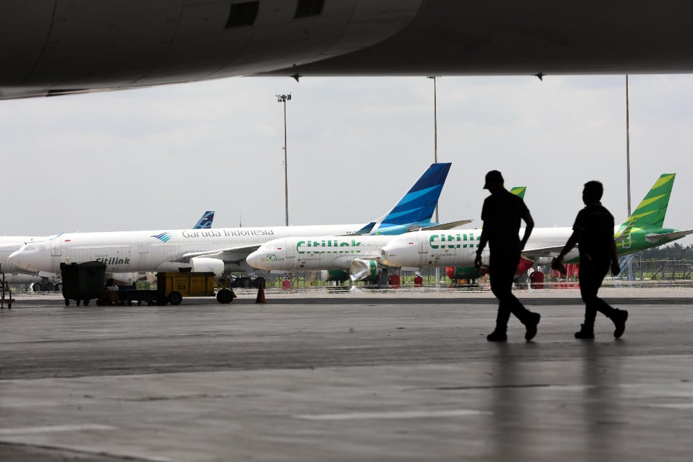 Pegawai melintas di depan pesawat milik grup Garuda Indonesia di Hanggar GMF AeroAsia Bandara Soekarno Hatta, Tangerang, Banten, Kamis (24/4/2025). Bisnis/Himawan L Nugraha