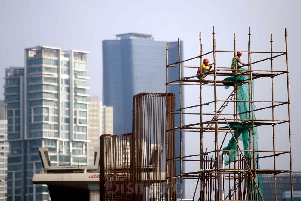 Siluet pekerja menyelesaikan proyek pembangunan gedung di Jakarta. Bisnis/Nurul Hidayat
