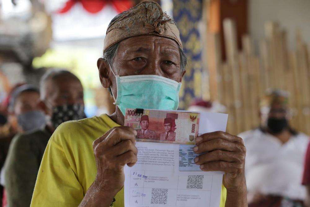 Warga menerima bantuan sosial alias bansos dari pemerintah/kemensos
