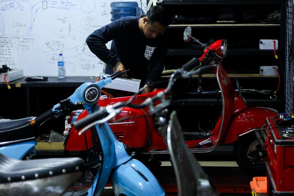 Mekanik menyelesaikan konversi vespa bahan bakar minyak (BBM) ke listrik di Jakarta, Selasa (29/8/2023)./Bisnis-Suselo Jati
