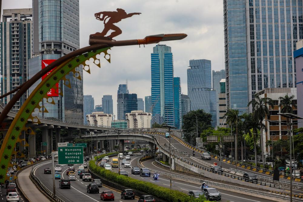 Kendaraan melintas dengan latar belakang jajaran gedung bertingkat di Jakarta. / Bisnis-Abdurachman