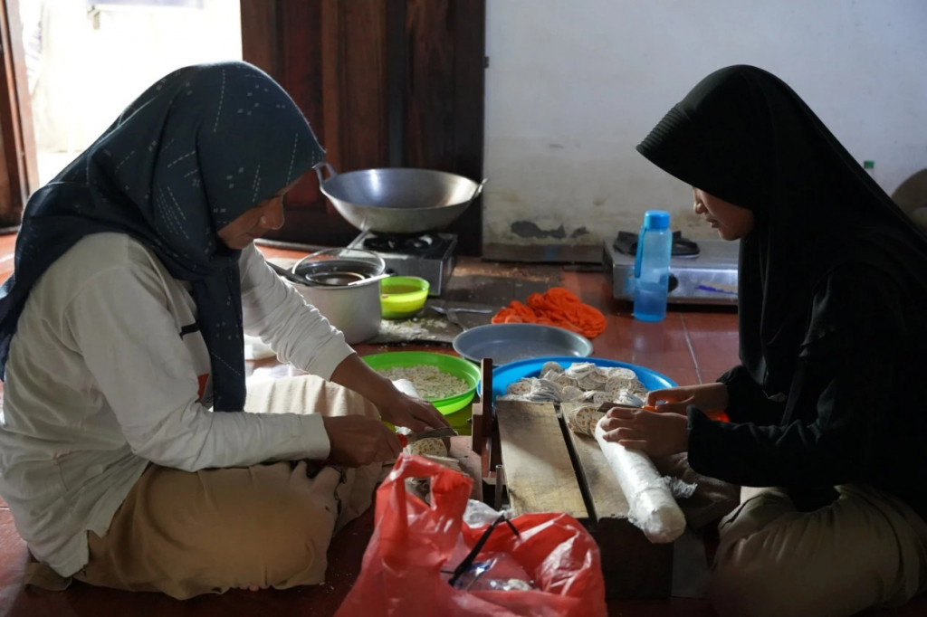 Tiara saat membantu ibunda membuah keripik untuk dijual. Foto: UGM