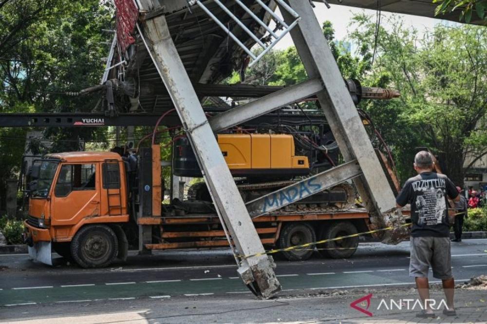 Petugas melakukan proses evakuasi truk bermuatan alat berat yang menabrak jembatan penyeberangan orang (JPO) di Jalan Kapten Tendean, Jakarta, Selasa (14/7/2026)./ANTARA FOTO/Fauzan/nym.