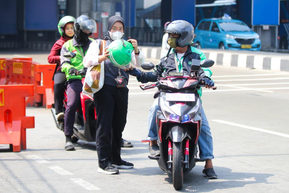 Pengemudi ojek online menurunkan penumpang di kawasan Lebak Bulus, Jakarta, Kamis (16/7/2026). Pemerintah mengancam akan menjatuhkan sanksi tegas hingga pencabutan izin terhadap perusahaan aplikator transportasi online seperti Grab, Gojek, hingga Maxim apabila terbukti melanggar ketentuan pembagian komisi pengemudi yang telah ditetapkan pemerintah. 
JIBI/Bisnis/Robby Fathan