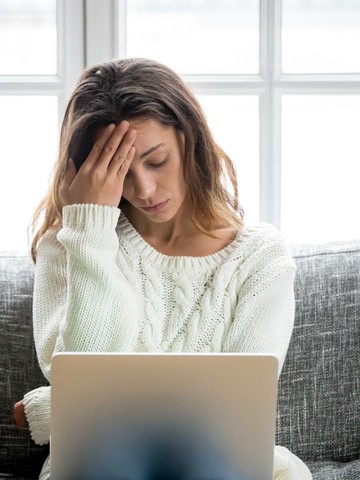 Ilustrasi wanita lelah bekerja depan laptop. Foto: Getty Images/iStockphoto/fizkes