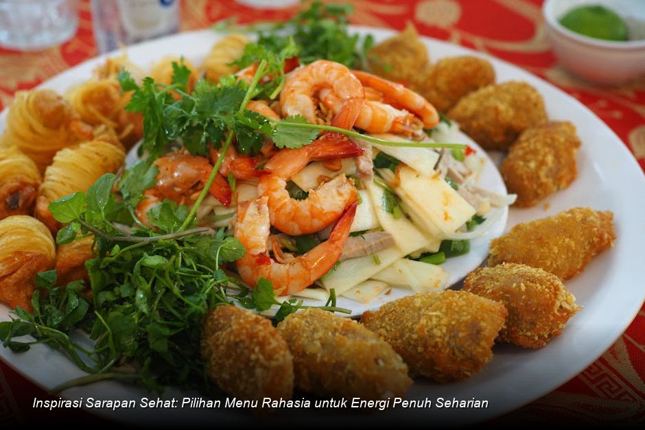 Piring berisi oatmeal dengan topping buah beri segar dan biji chia di atas meja kayu.