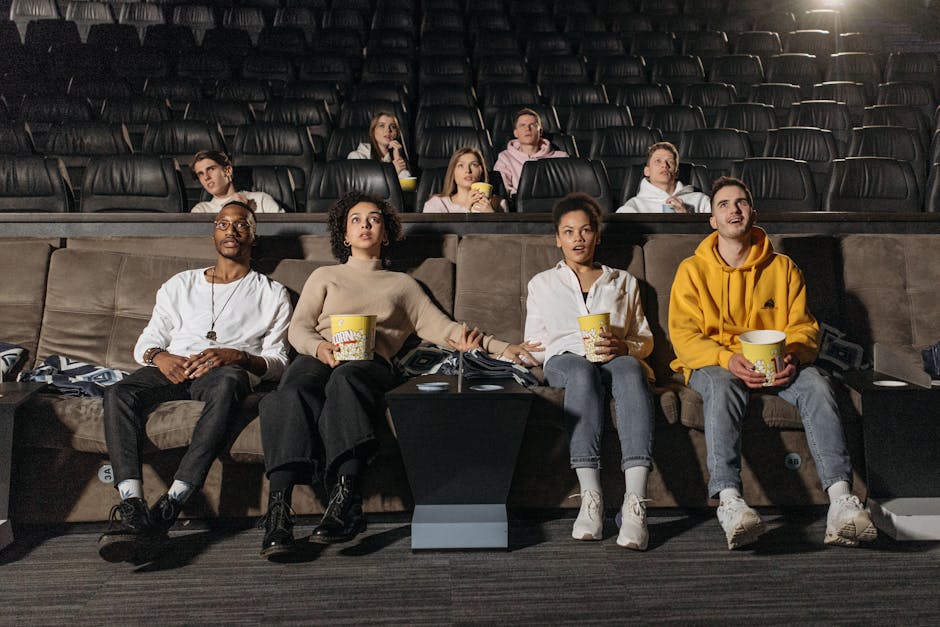 Seseorang sedang menonton film dengan ekspresi terinspirasi di depan layar yang menampilkan pemandangan matahari terbit.